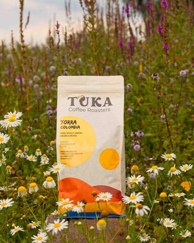 Bag of Torra Colombia by TUKA Coffee Roasters among wildflowers