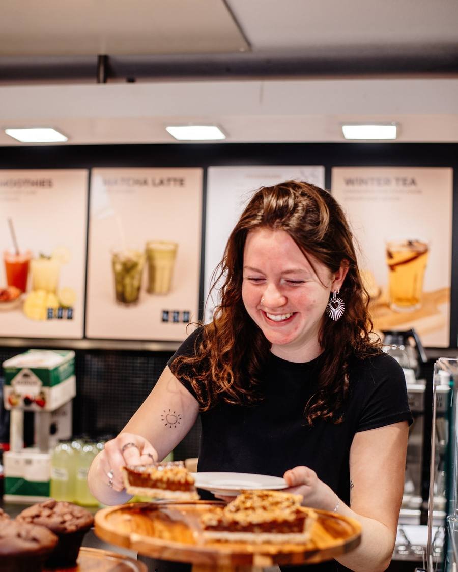 Staff member behind the counter with treats