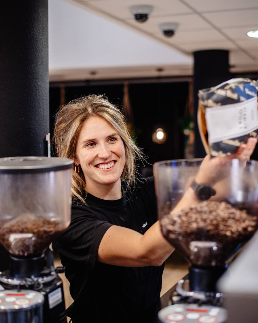Barista filling the grinder with fresh beans