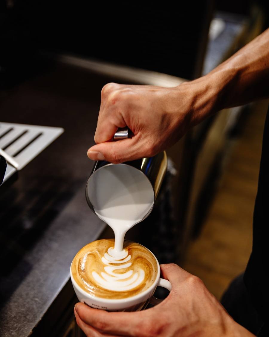 Steamed milk being poured into a cappuccino