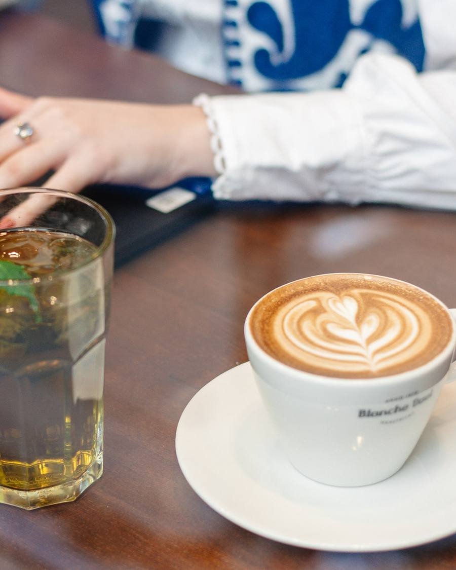 Fresh mint tea and cappuccino next to a laptop